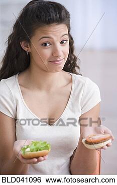 Stock Photo - hispanic girl 
holding hamburger. 
fotosearch - search 
stock photos, 
pictures, images, 
and photo clipart