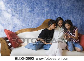 Stock Photography - hispanic mother 
and children relaxing 
on sofa. fotosearch 
- search stock 
photos, pictures, 
images, and photo 
clipart
