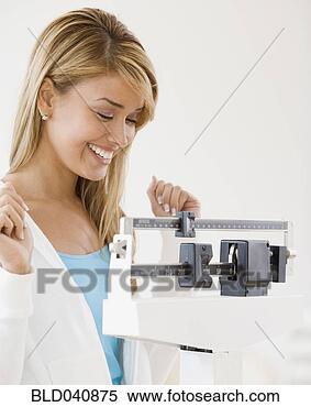 Stock Image - hispanic woman 
weighing self. 
fotosearch - search 
stock photos, 
pictures, images, 
and photo clipart