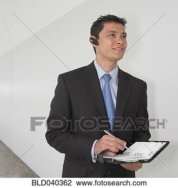 Stock Photo - mixed race businessman 
writing in date 
book. fotosearch 
- search stock 
photos, pictures, 
images, and photo 
clipart