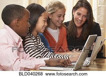 Stock Photo - multi-ethnic children 
and teacher typing 
looking at laptops. 
fotosearch - search 
stock photos, 
pictures, images, 
and photo clipart