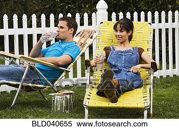 Stock Image - multi-ethnic couple 
relaxing in lawn 
chairs. fotosearch 
- search stock 
photos, pictures, 
images, and photo 
clipart