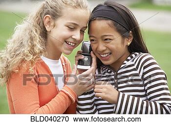 Stock Photography - multi-ethnic girls 
listening to cell 
phone. fotosearch 
- search stock 
photos, pictures, 
images, and photo 
clipart