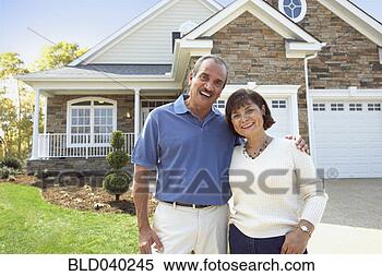 Stock Image - senior hispanic 
couple in front 
of house. fotosearch 
- search stock 
photos, pictures, 
images, and photo 
clipart