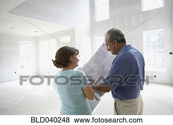 Stock Photo - senior hispanic 
couple looking 
at blueprints 
in new house. 
fotosearch - search 
stock photos, 
pictures, images, 
and photo clipart