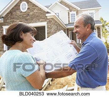 Stock Photo - senior hispanic 
couple looking 
at blueprints 
for new house. 
fotosearch - search 
stock photos, 
pictures, images, 
and photo clipart