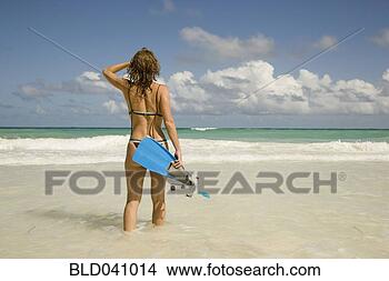 Stock Photo - woman carrying 
snorkeling gear 
at beach. fotosearch 
- search stock 
photos, pictures, 
images, and photo 
clipart