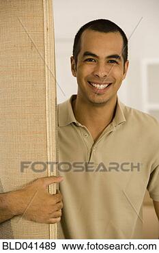 Stock Photograph - young man holding 
rolled rug. fotosearch 
- search stock 
photos, pictures, 
images, and photo 
clipart