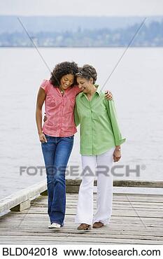 Stock Photo - african american 
mother and adult 
daughter walking 
on pier. fotosearch 
- search stock 
photos, pictures, 
images, and photo 
clipart