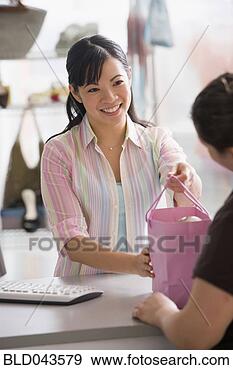 Stock Photograph - chinese sales 
clerk handing 
purchase to customer. 
fotosearch - search 
stock photos, 
pictures, images, 
and photo clipart