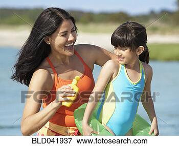 Picture - hispanic mother 
applying sunscreen 
on daughter. fotosearch 
- search stock 
photos, pictures, 
images, and photo 
clipart