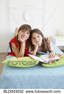 Stock Photo - hispanic sisters 
laying on bed. 
fotosearch - search 
stock photos, 
pictures, images, 
and photo clipart