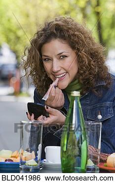 Stock Photo - hispanic woman 
applying lip gloss. 
fotosearch - search 
stock photos, 
pictures, images, 
and photo clipart