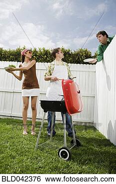 Stock Photo - man reaching plate 
over fence at 
barbecue. fotosearch 
- search stock 
photos, pictures, 
images, and photo 
clipart