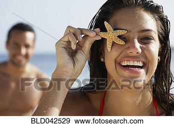 Stock Photograph - south american 
woman holding 
starfish over 
eye. fotosearch 
- search stock 
photos, pictures, 
images, and photo 
clipart