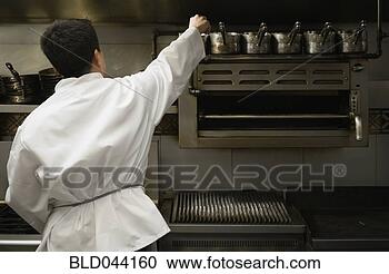 Stock Photography - asian male chef 
reaching for pot. 
fotosearch - search 
stock photos, 
pictures, images, 
and photo clipart