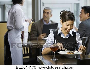 Stock Image - asian woman eating 
at restaurant. 
fotosearch - search 
stock photos, 
pictures, images, 
and photo clipart