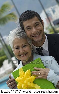 Picture - hispanic man giving 
gift to mother. 
fotosearch - search 
stock photos, 
pictures, images, 
and photo clipart