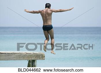 Stock Photo - hispanic man jumping 
off dock. fotosearch 
- search stock 
photos, pictures, 
images, and photo 
clipart