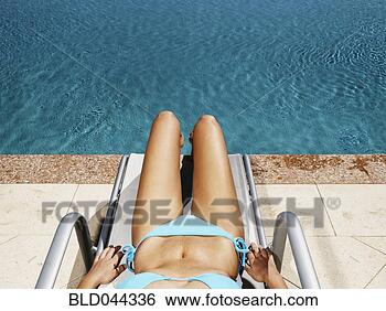 Stock Photo - hispanic woman 
in lounge chair 
next to swimming 
pool. fotosearch 
- search stock 
photos, pictures, 
images, and photo 
clipart