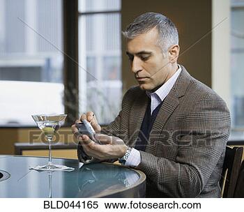 Stock Image - middle eastern 
man using electronic 
organizer at bar. 
fotosearch - search 
stock photos, 
pictures, images, 
and photo clipart