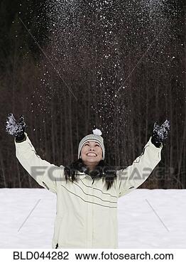 Stock Photo - mixed race woman 
playing with snow. 
fotosearch - search 
stock photos, 
pictures, images, 
and photo clipart
