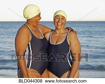 Stock Photo - mixed race women 
in swimming caps 
on beach. fotosearch 
- search stock 
photos, pictures, 
images, and photo 
clipart