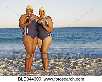 Stock Photograph - mixed race women 
with medals on 
beach. fotosearch 
- search stock 
photos, pictures, 
images, and photo 
clipart