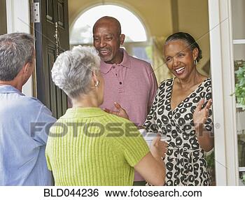 Stock Photo - multi-ethnic senior 
couples greeting 
in doorway. fotosearch 
- search stock 
photos, pictures, 
images, and photo 
clipart