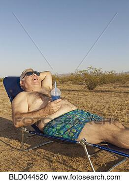 Stock Photography - senior mixed race 
man sunbathing 
in desert. fotosearch 
- search stock 
photos, pictures, 
images, and photo 
clipart