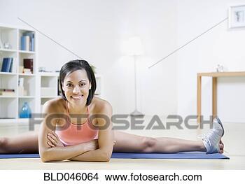 Stock Photo - african american 
woman stretching 
on yoga mat. fotosearch 
- search stock 
photos, pictures, 
images, and photo 
clipart