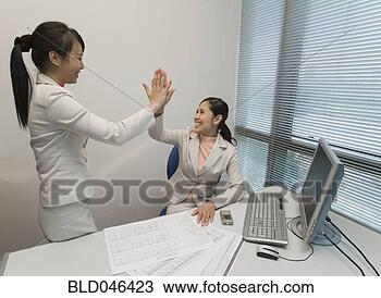 Stock Photo - asian businesswomen 
high-fiving. fotosearch 
- search stock 
photos, pictures, 
images, and photo 
clipart
