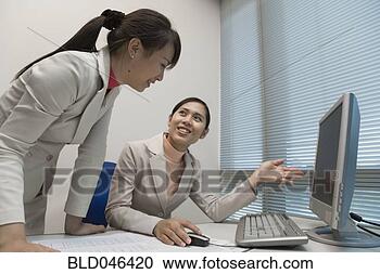 Stock Photography - asian businesswomen 
looking at computer. 
fotosearch - search 
stock photos, 
pictures, images, 
and photo clipart
