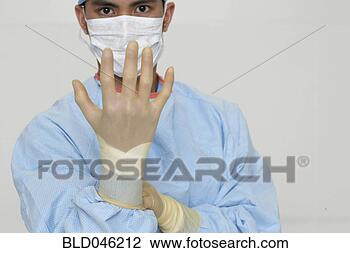 Stock Photo - asian male medical 
professional putting 
on glove. fotosearch 
- search stock 
photos, pictures, 
images, and photo 
clipart