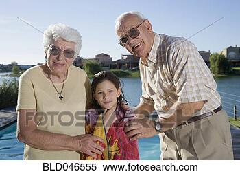 Stock Image - hispanic grandparents 
and granddaughter 
next to swimming 
pool. fotosearch 
- search stock 
photos, pictures, 
images, and photo 
clipart