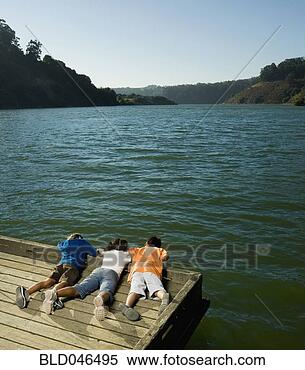 Stock Image - multi-ethnic children 
laying on dock. 
fotosearch - search 
stock photos, 
pictures, images, 
and photo clipart