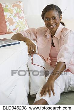 Stock Photo - senior african 
american woman 
next to laptop. 
fotosearch - search 
stock photos, 
pictures, images, 
and photo clipart