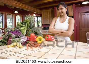 Stock Photo - hispanic woman 
next to fresh 
vegetables in 
kitchen. fotosearch 
- search stock 
photos, pictures, 
images, and photo 
clipart