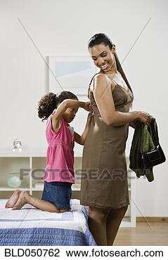 Stock Photo - mixed race girl 
zipping mother’s 
dress. fotosearch 
- search stock 
photos, pictures, 
images, and photo 
clipart