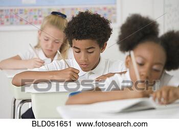 Stock Photography - multi-ethnic children 
writing at desks 
in classroom. 
fotosearch - search 
stock photos, 
pictures, images, 
and photo clipart