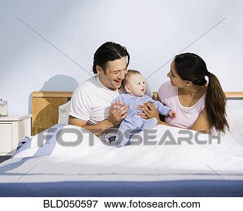 Picture - multi-ethnic parents 
and baby in bed. 
fotosearch - search 
stock photos, 
pictures, images, 
and photo clipart