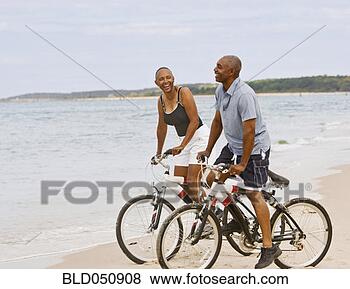 Stock Photo - senior african 
american couple 
riding bicycles 
on beach. fotosearch 
- search stock 
photos, pictures, 
images, and photo 
clipart