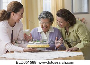 Stock Photo - senior hispanic 
woman celebrating 
birthday with 
family. fotosearch 
- search stock 
photos, pictures, 
images, and photo 
clipart