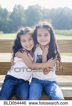 Stock Photo - hispanic sisters 
hugging on bench. 
fotosearch - search 
stock photos, 
pictures, images, 
and photo clipart