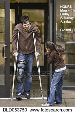 Stock Photography - mixed race girl 
holding door for 
man on crutches. 
fotosearch - search 
stock photos, 
pictures, images, 
and photo clipart