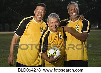Stock Photo - multi-ethnic men 
holding soccer 
ball. fotosearch 
- search stock 
photos, pictures, 
images, and photo 
clipart