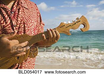 Picture - pacific islander 
man playing instrument 
at beach. fotosearch 
- search stock 
photos, pictures, 
images, and photo 
clipart