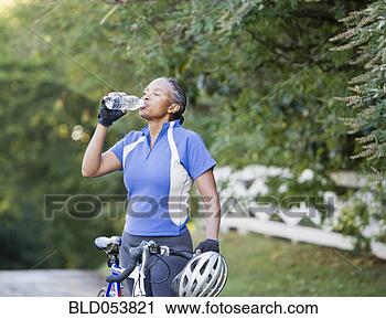 Stock Photography - senior african 
female cyclist 
drinking water. 
fotosearch - search 
stock photos, 
pictures, images, 
and photo clipart