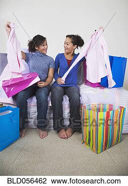 Stock Photo - african twin sisters 
comparing purchases. 
fotosearch - search 
stock photos, 
pictures, images, 
and photo clipart