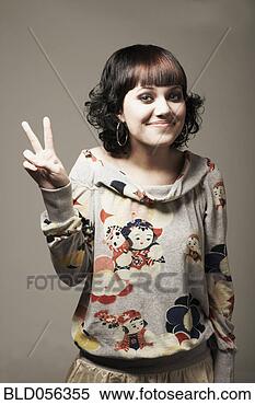 Stock Image - mixed race woman 
making peace sign 
hand gesture. 
fotosearch - search 
stock photos, 
pictures, images, 
and photo clipart